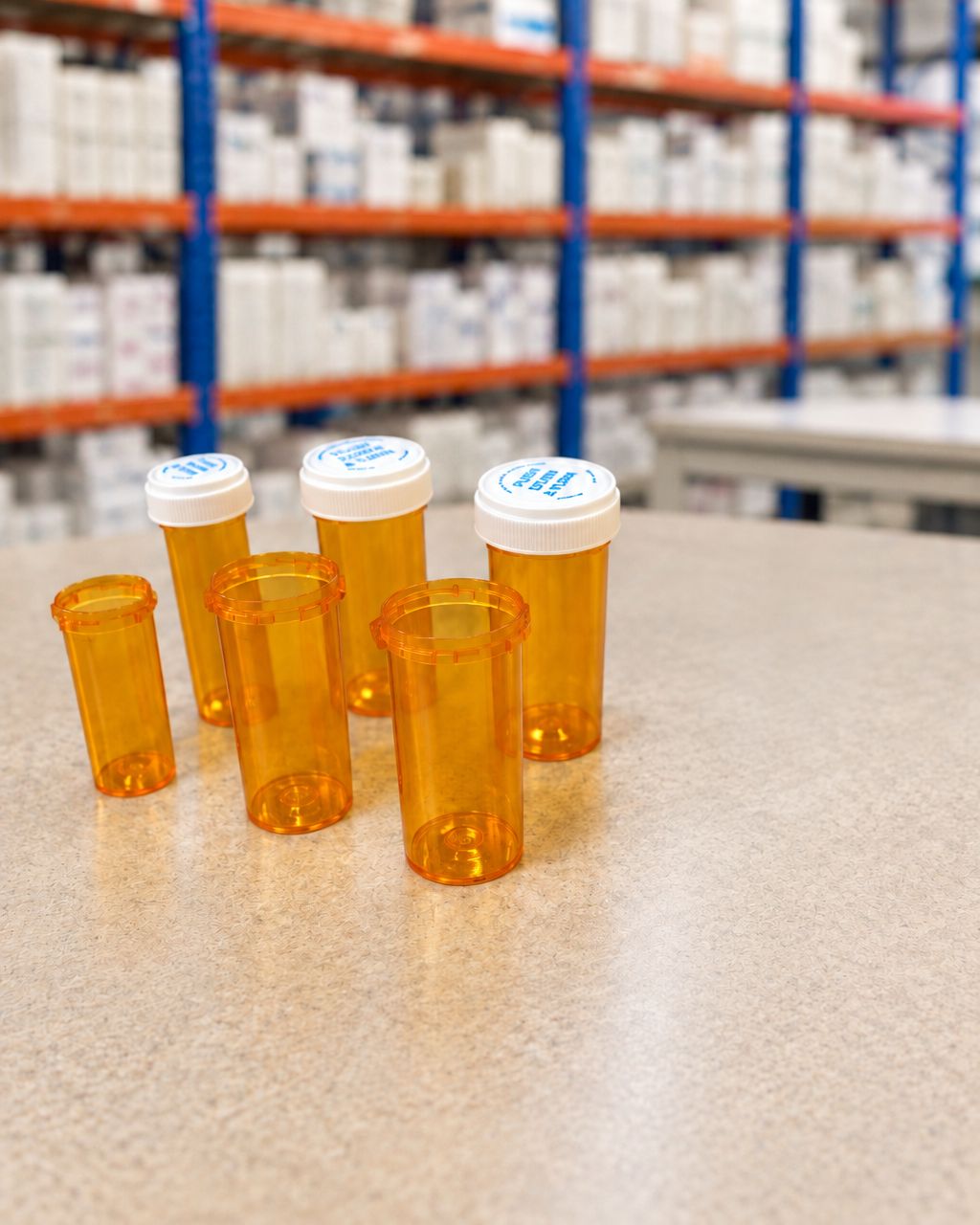 Six amber prescription vials on a pharmacy counter